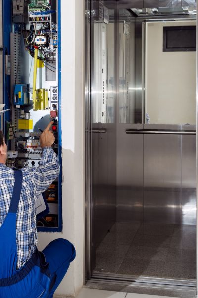 lift repair engineer working on a lift control panel